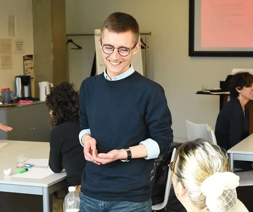 Jimmy en plein discussion avec une participante à l'un de ses ateliers dans une salle de réunion.